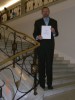 Professor Andrzej Czyżewski holding certificate for Multimedia Noise Monitoring System in Polish Parliament