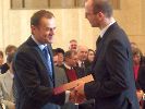 Prezes Rady Ministrów, Donald Tusk, wręcza nagrodę Piotrowi Szczuko